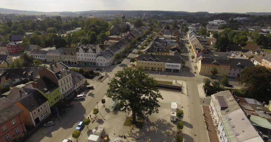 Two people sit down on a bench in a small town during the day