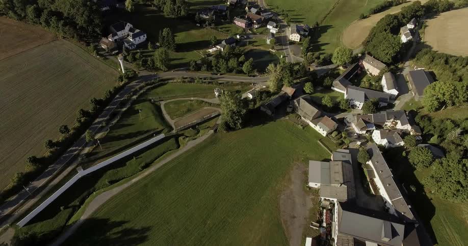 A road winds through a village nestled in a farming valley