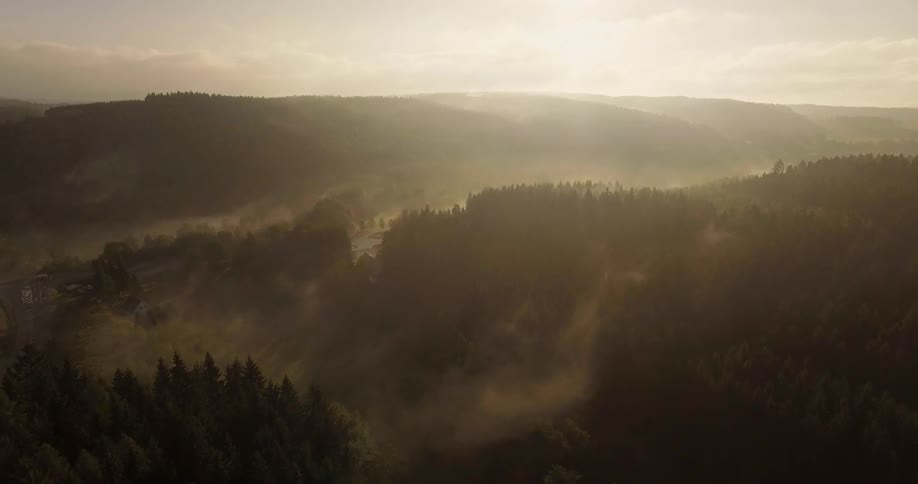 A foggy valley is being filmed from a drone
