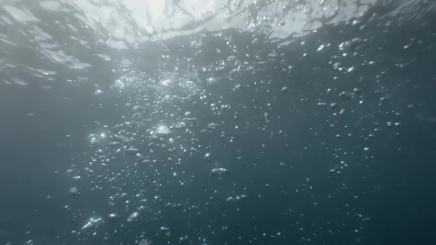 Underwater view of a paddle splashing into the water