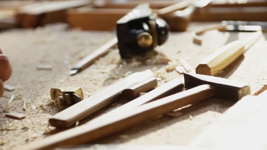 A person uses tools at a workbench