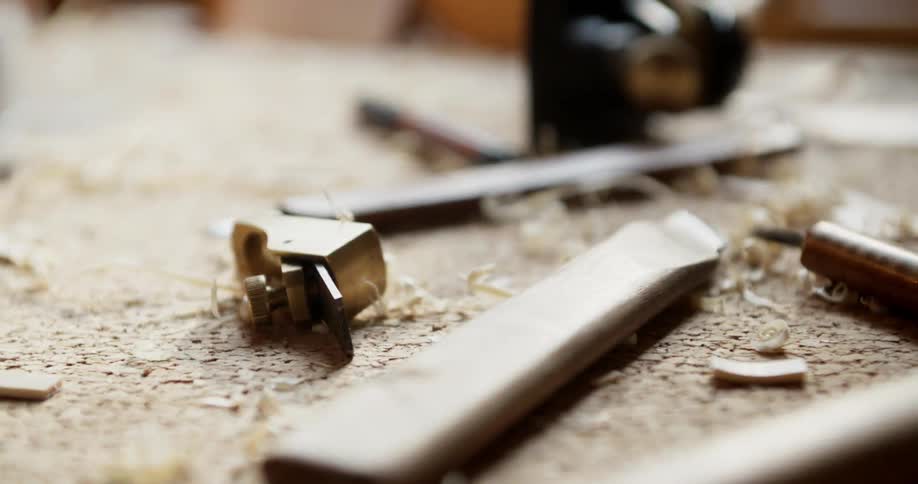 Wood shavings and tools sit atop a workshop table