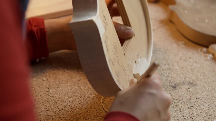 A man whittles a handmade violin