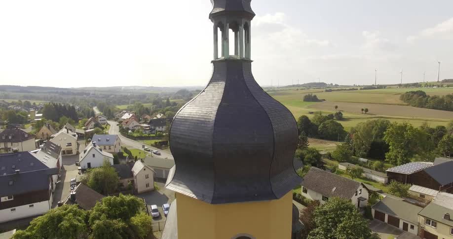 A building with a tall steeple sits in a small community