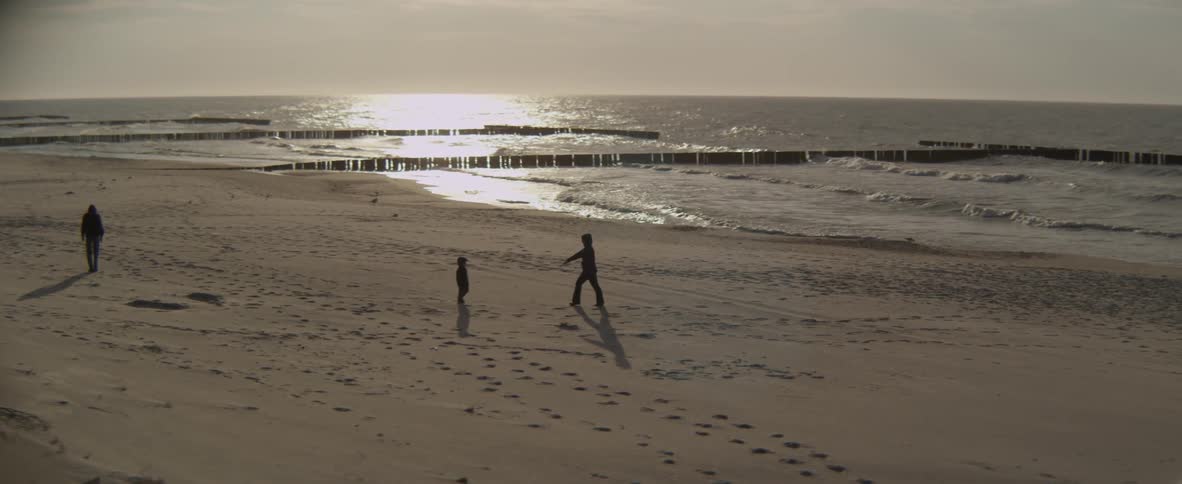 A woman and young child walk on the beach