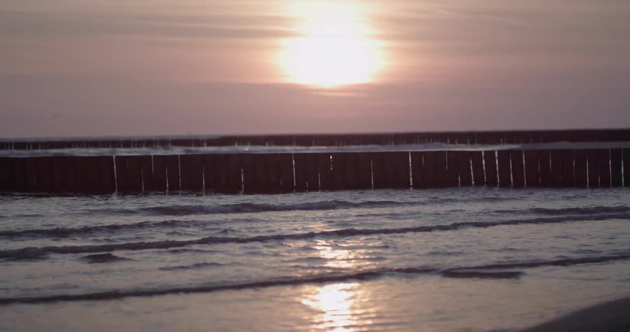 Waves splash to shore at sunset