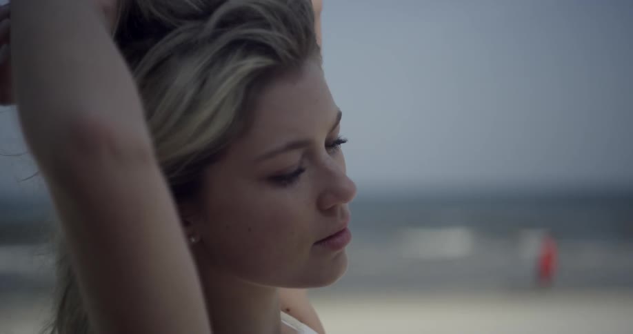 A woman is stretching on the windy beach
