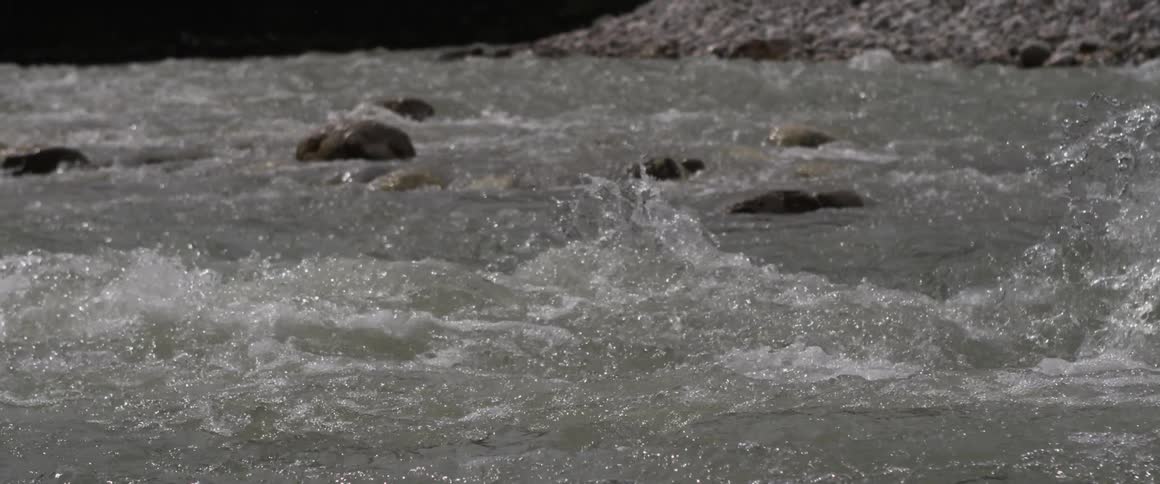 Water rapids are crashing over small rocks
