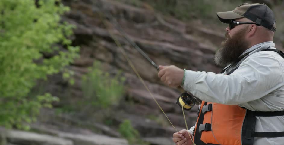 A fisherman casts his line into the water
