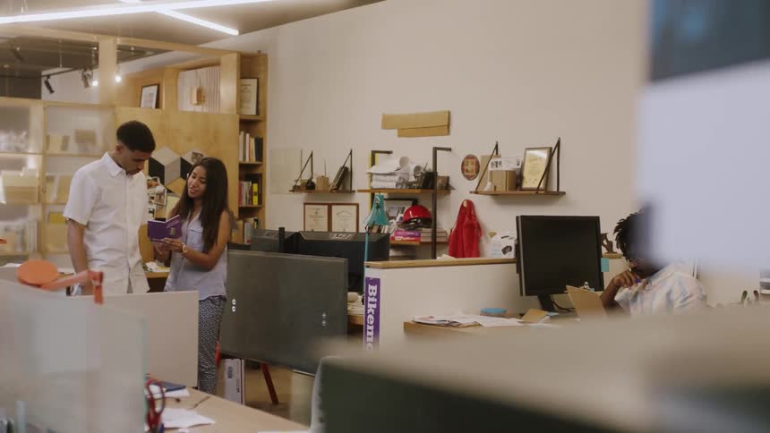 A man and woman walk past an office place