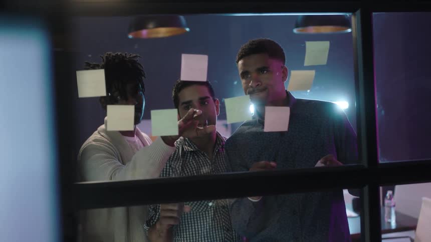 Employees look at post it notes attached to a window