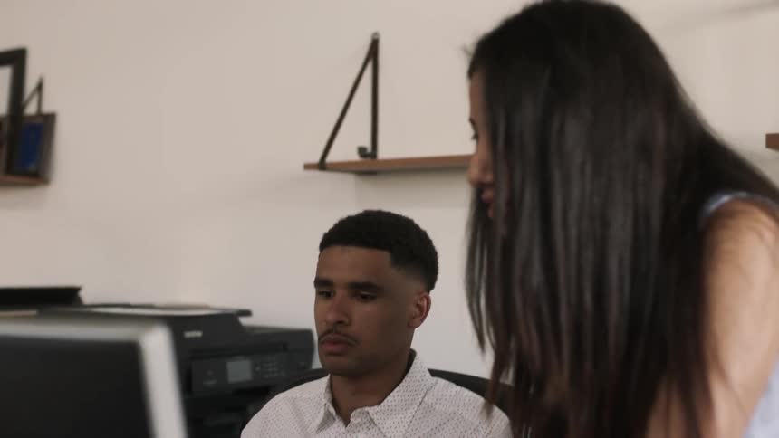 A man and woman work together in an office