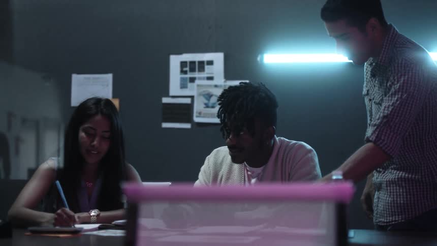 A group of young people are sitting in an office having a meeting