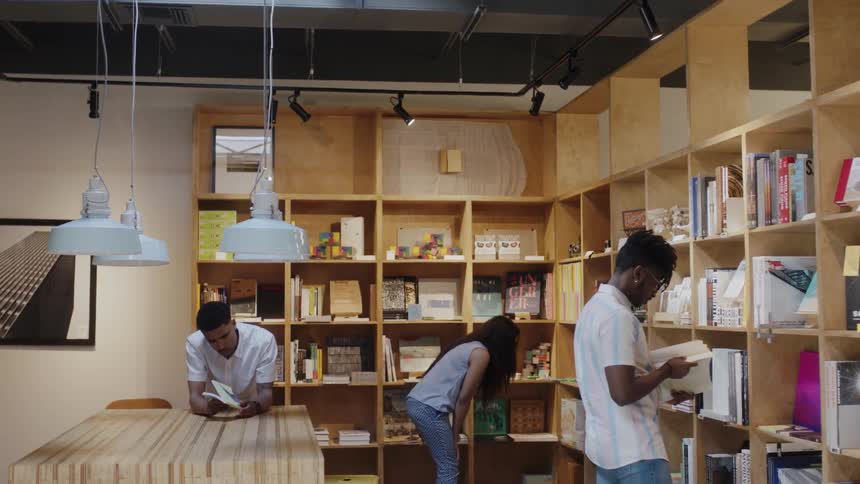People peruse books on wood shelves