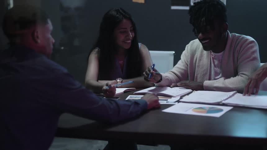 People sit around a table writing and working together
