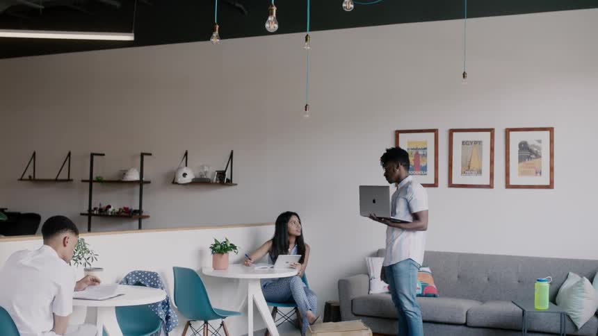 A group of people sit at tables and work