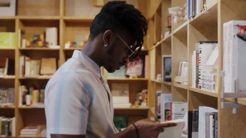 A man looks at a book in a library