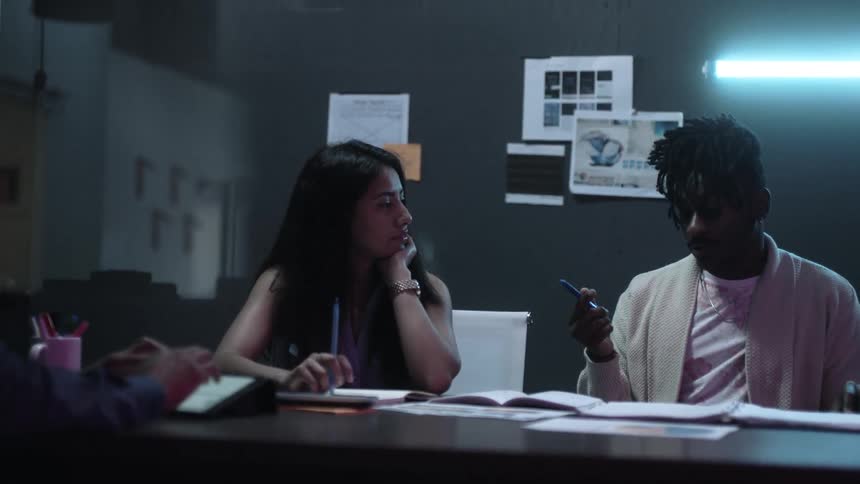 Workers sit at a table and work together