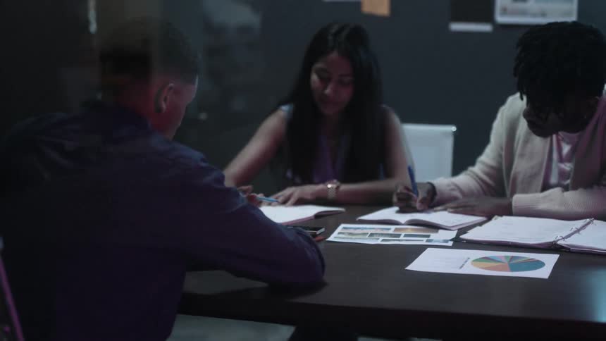 People sit around a conference table talking