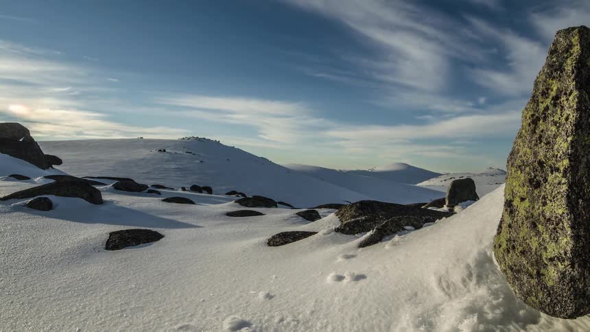 Snow covers a rocky landscape in the daytime