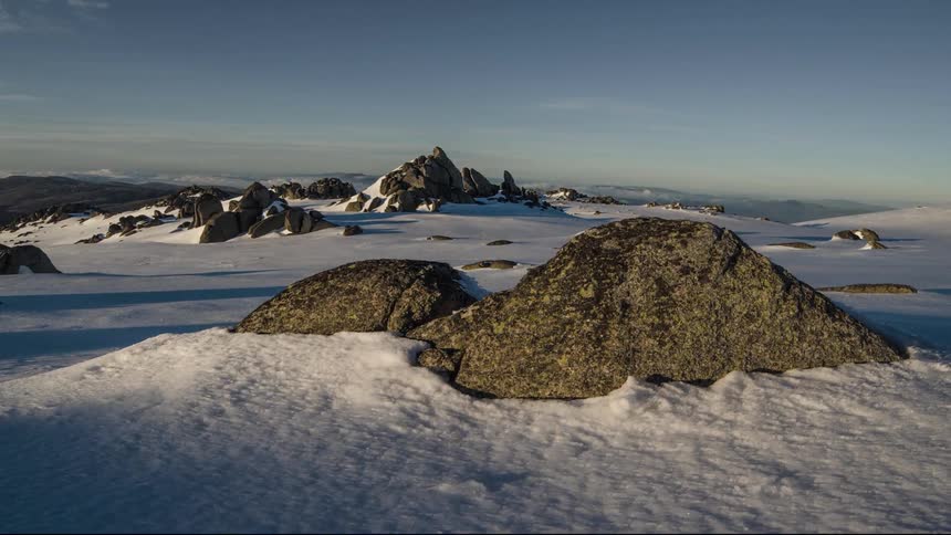 Aerial shot of rocky peaks rising out of deep snow