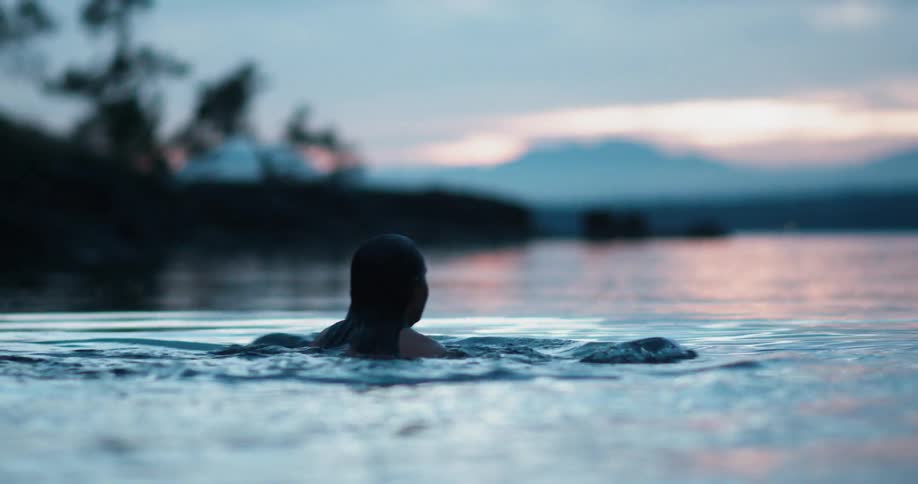 A woman wades in neck deep water