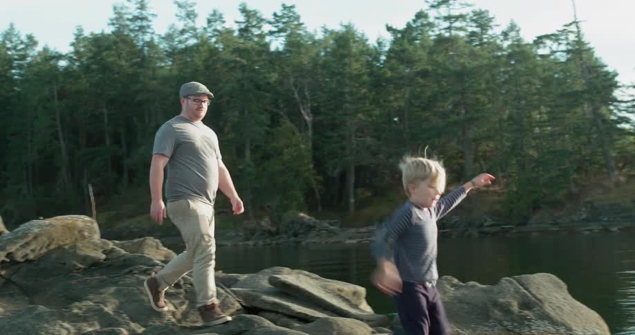 Man and boy in a rocky area that is lakeside