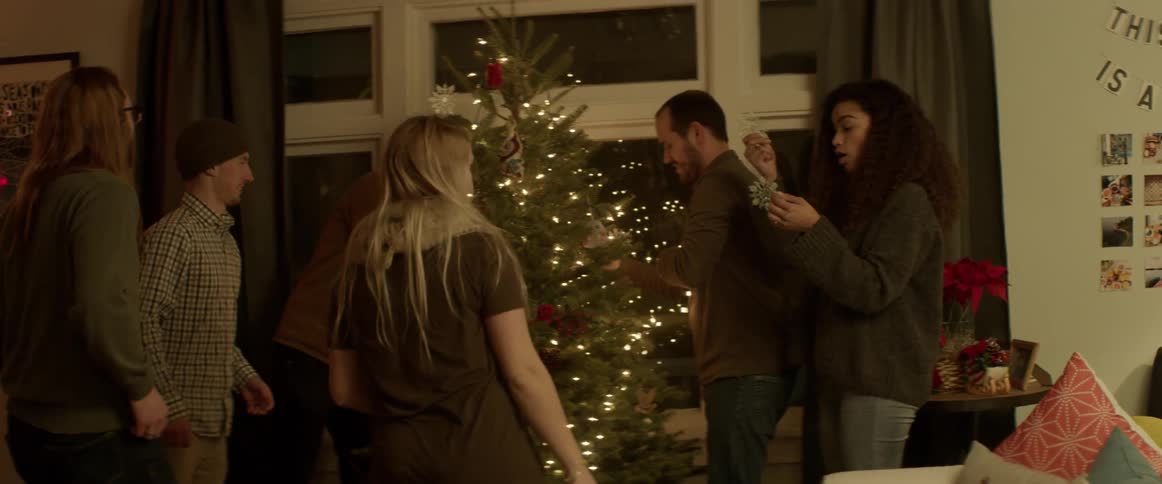 A group of people decorate a christmas tree
