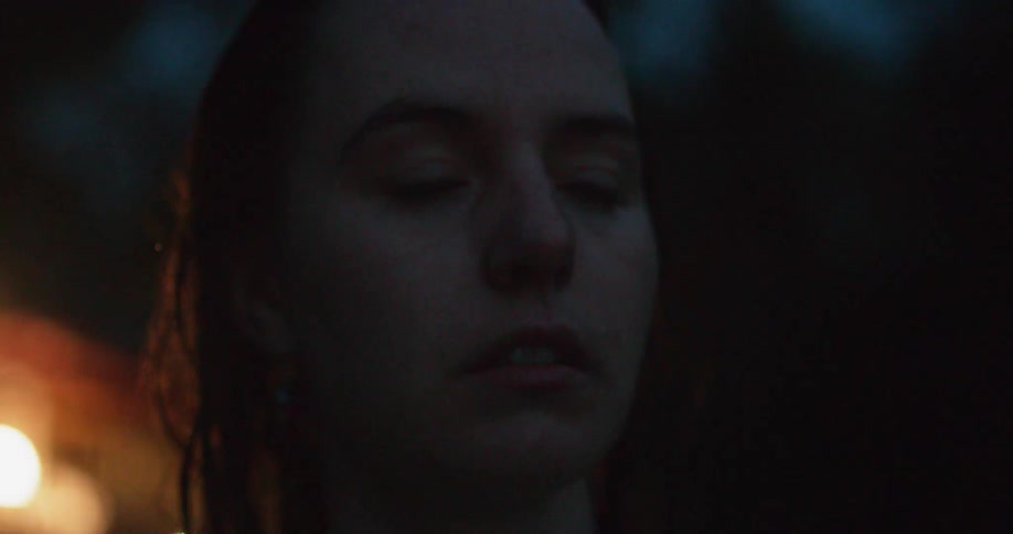 Woman looks around outside at night