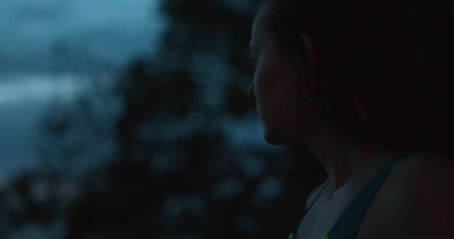 A young woman stares out to the water