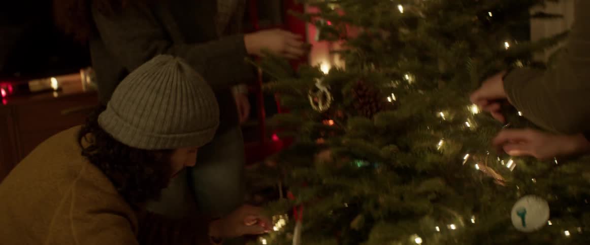 Man arranges lights on a christmas tree