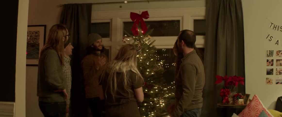 Friends decorate a christmas tree in a living room