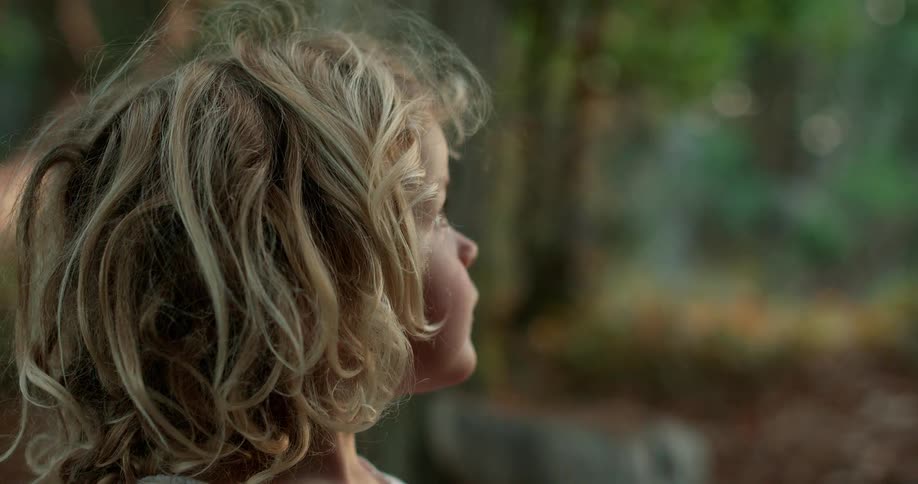 A young girl looks out a window