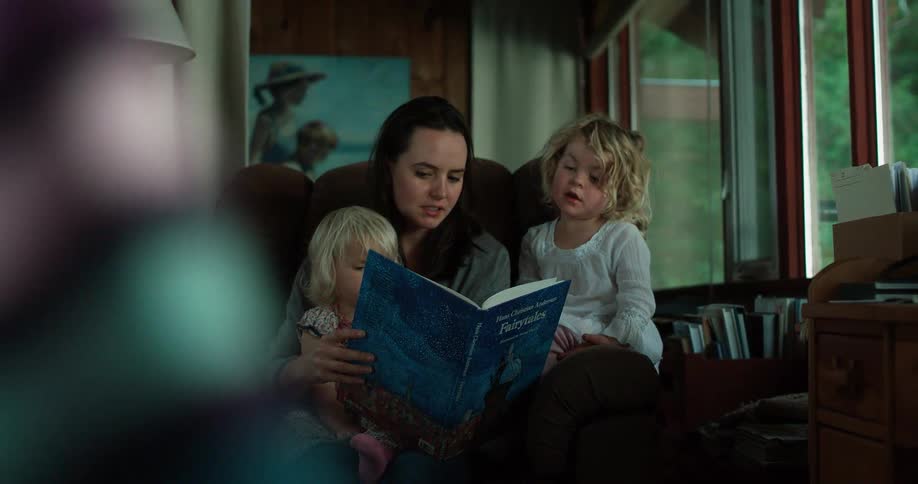 Mom and children read stories in a library