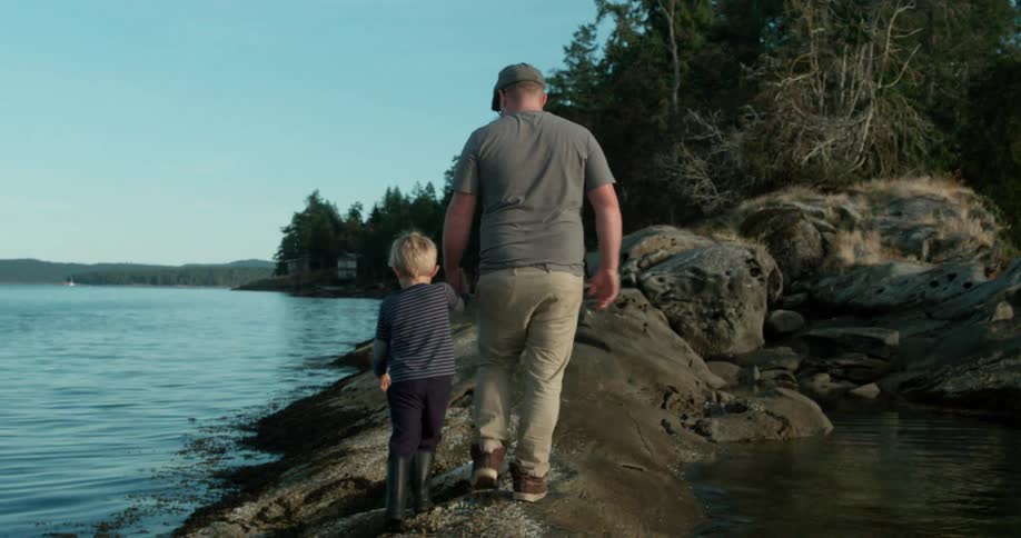 Man and child near the edge of a body of water