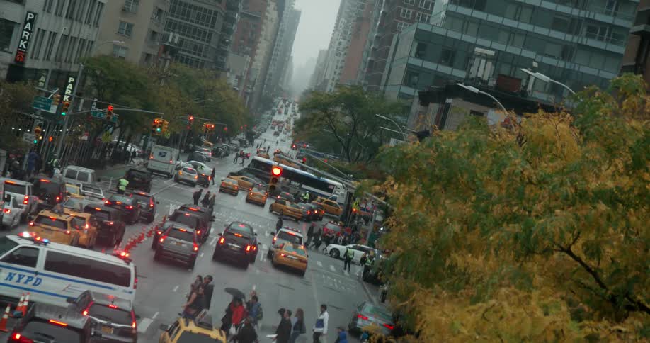 Vehicles and pedestrians navigate a busy city street