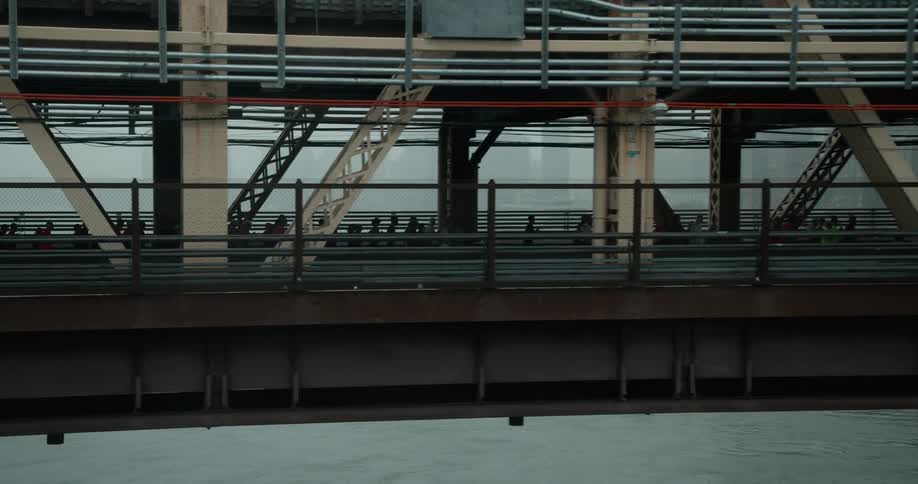 Marathoners run across a city bridge on a foggy day