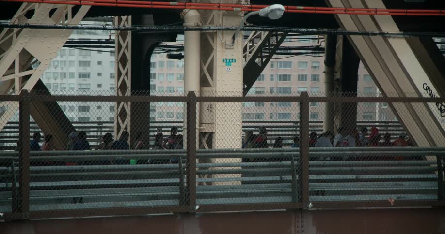 People are crossing a bridge in a city