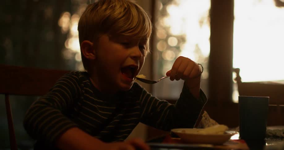 A boy grabs a spoonful of food