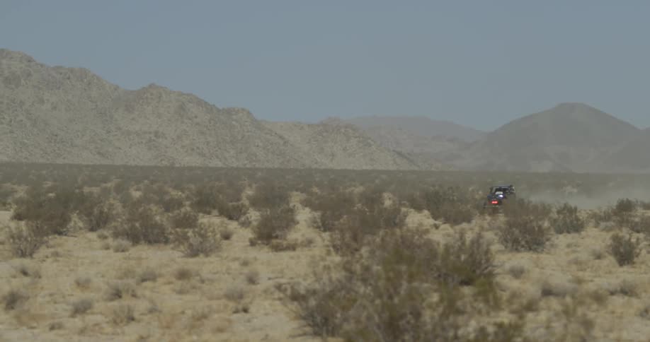 An off road vehicle travels through the desert