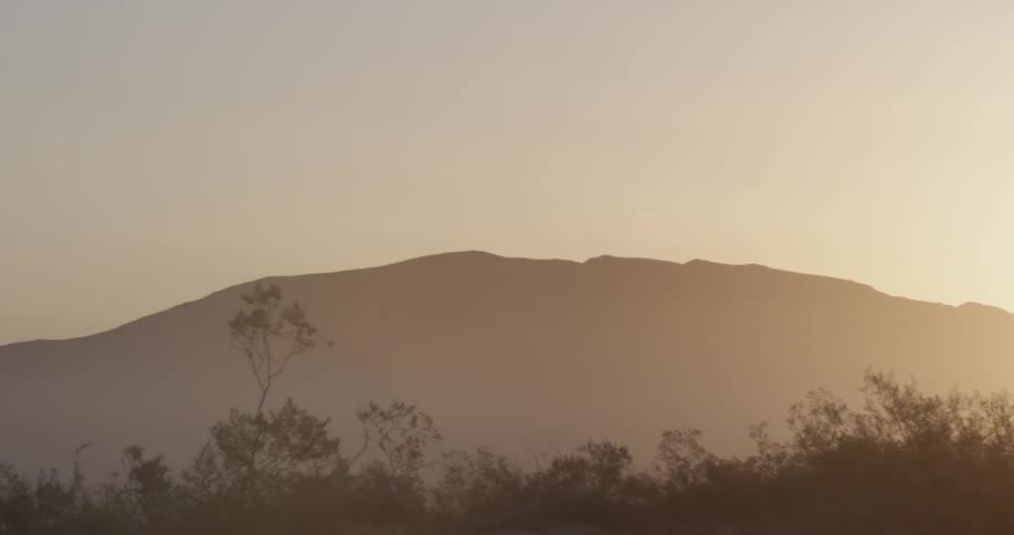 The sun sets over a mountain range
