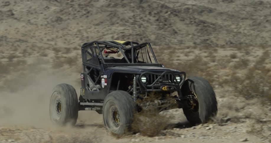 An off road vehicle is driving in the desert