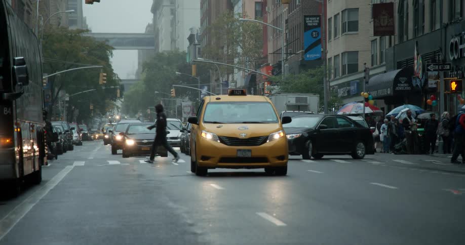 People running and walking across a busy city street