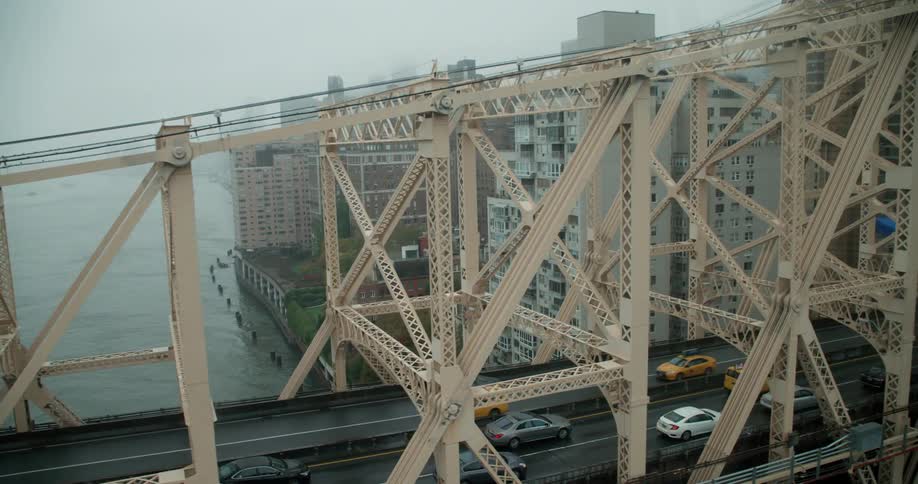Cars drive over a city bridge on a foggy day