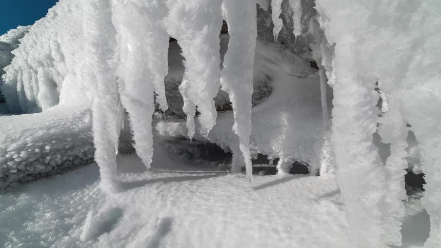 Ice is melting and droplets of water are falling beneath