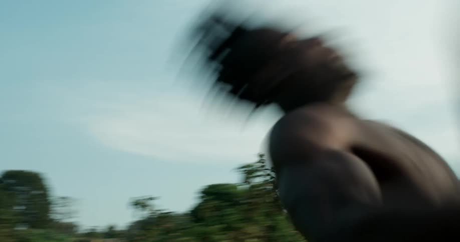 A man performs cartwheels and flips in the grass