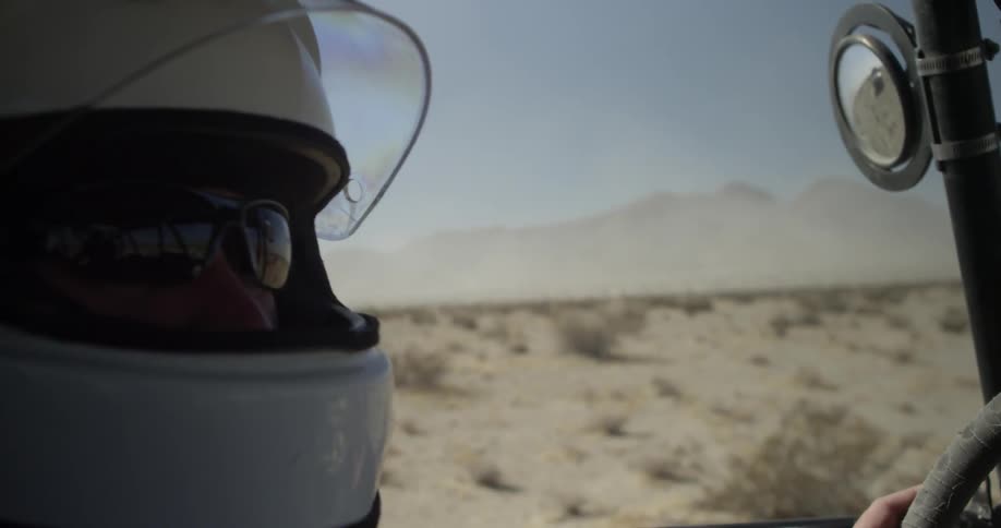 A man sits in the driver's seat of an off road vehicle