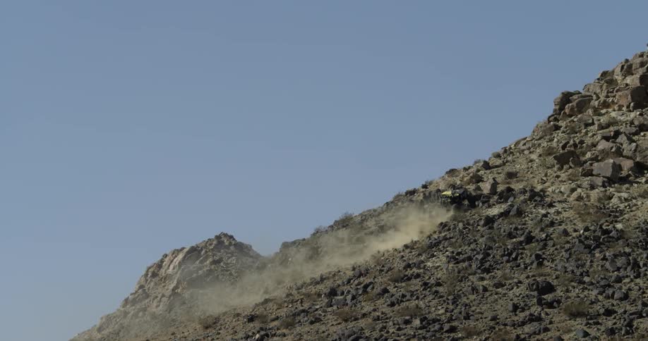 An off road vehicle drives up a rocky mountainside