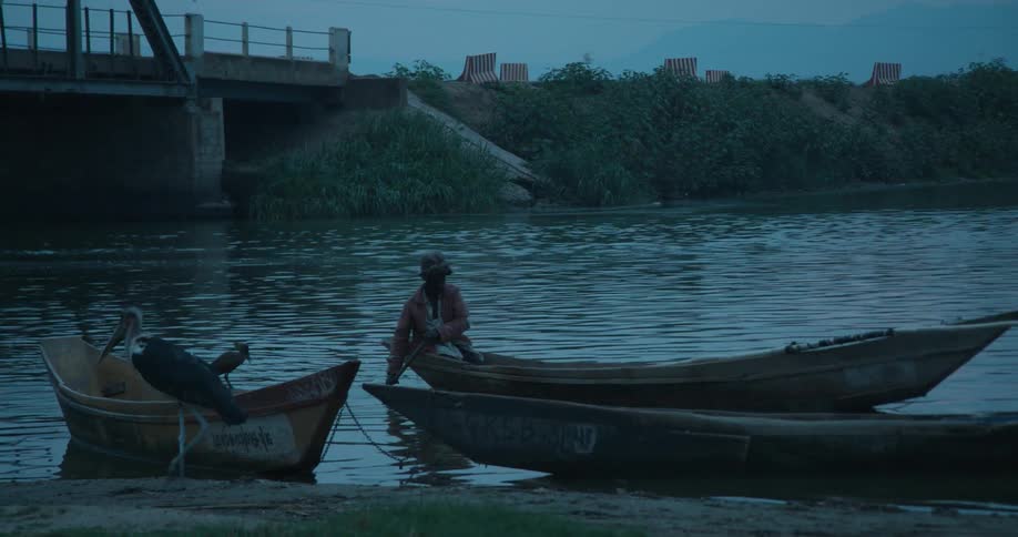 A man paddles his boat down the river