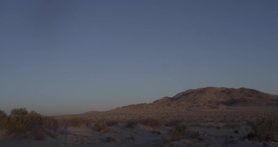 A desert landscape is shown at sunset